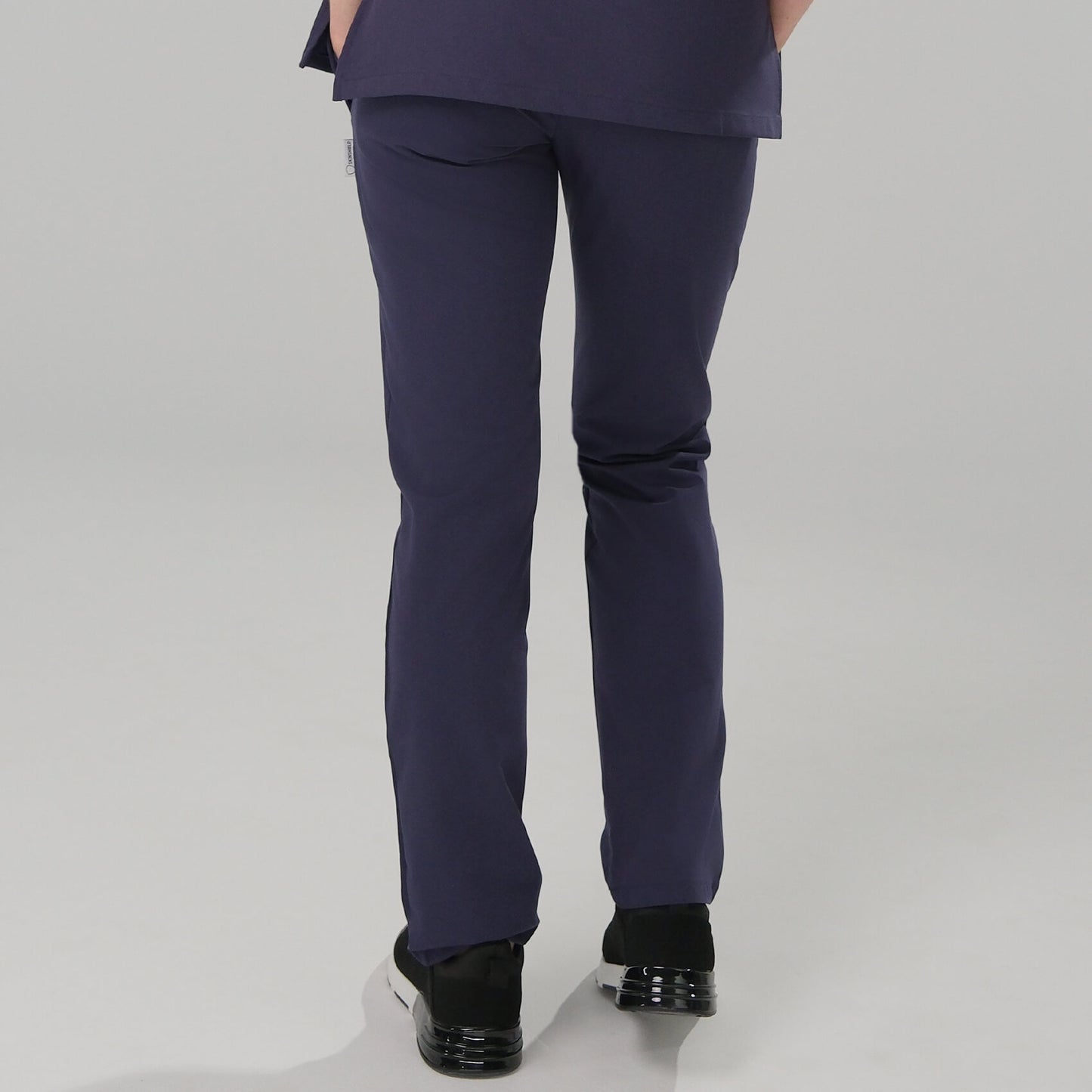 Woman wearing navy blue scrub trousers.
